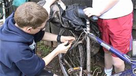 Olly adjusts Joe's brakes after doing some urgent repairs to his hub, at Quantock Hills Youth Hostel